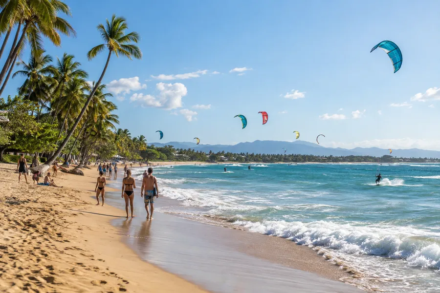 Cometas de kitesurf sobre la bahía de Cabarete bordeada de palmeras